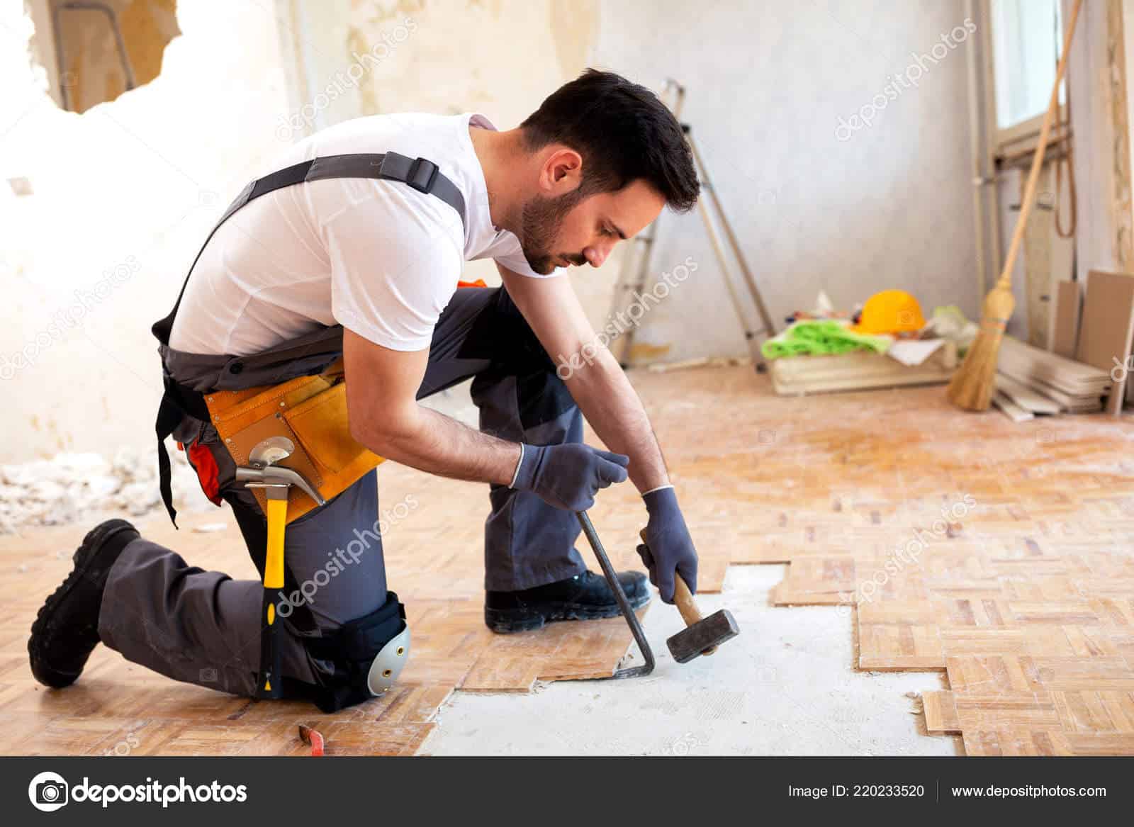 Young worker removing old flooring with adequate removal tolls